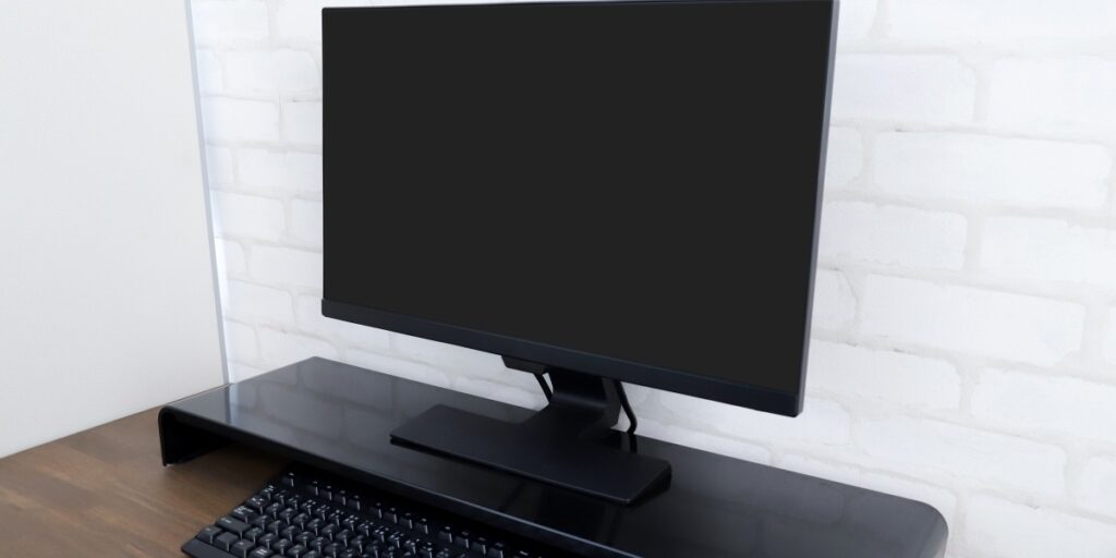 木製デスクに設置されたモニターとキーボードのパソコンセットの実物写真。出張買取対象のデスクトップPCや周辺機器として紹介。